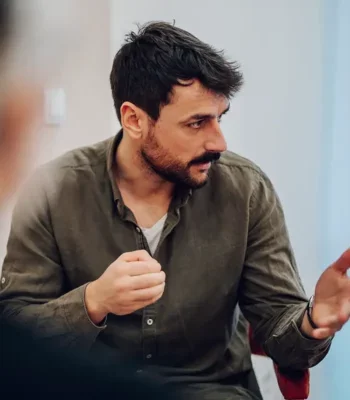 Young man in a group work setting, in discussion with others