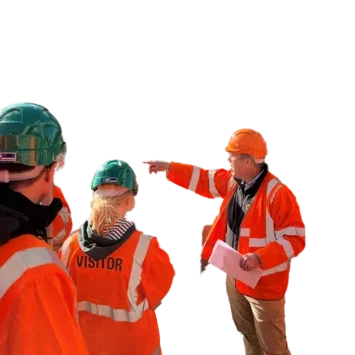 Group of people in high-vis jackets and hard hats being shown around the site of a sugar silo