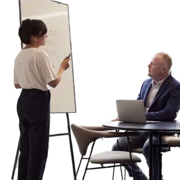 Male and female senior co-workers next to a whiteboard in an office