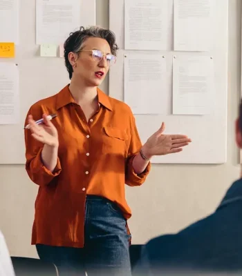 Professional woman in a meeting room speaking to others