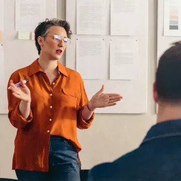 Professional woman in a meeting room speaking to others