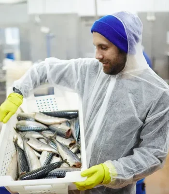 Photo of a man holding a crate of fresh fish